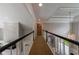 Upper hallway showcasing modern trim, stone wall, chandelier, and open railing at 4115 Falls Ridge Dr, Johns Creek, GA 30022