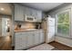 Compact kitchenette with classic cabinets, microwave, white fridge, and window views of outdoor greenery at 4115 Falls Ridge Dr, Johns Creek, GA 30022