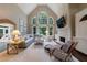 Spacious living room with a stone fireplace, large arched window, and comfortable seating at 4115 Falls Ridge Dr, Johns Creek, GA 30022
