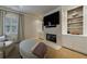 Cozy living room with a fireplace, custom built-ins, and an ottoman at 4115 Falls Ridge Dr, Johns Creek, GA 30022