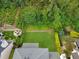 Aerial view of a backyard with a fire pit, trimmed hedges, and lush green grass at 4206 Moccasin Trl, Woodstock, GA 30189
