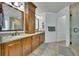 Dual sink bathroom features granite countertops, wood cabinets, mirrors, and access to a walk-in shower at 4206 Moccasin Trl, Woodstock, GA 30189