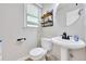 Charming powder room featuring a pedestal sink, decorative mirror, and a wooden shelf for stylish storage at 4206 Moccasin Trl, Woodstock, GA 30189