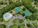 A community pool with tennis courts surrounded by parking spaces and mature shade trees at 4206 Moccasin Trl, Woodstock, GA 30189