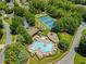 Aerial shot of a community pool, tennis courts and parking nestled among mature trees at 4206 Moccasin Trl, Woodstock, GA 30189