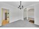 Spacious empty room showing wainscoting, neutral carpet, and access to the kitchen at 4206 Moccasin Trl, Woodstock, GA 30189
