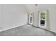 Versatile empty room showcasing neutral carpet, natural light, and serene backyard views at 4206 Moccasin Trl, Woodstock, GA 30189