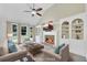 Staged living room with fireplace, built-in shelving, vaulted ceiling, ceiling fan, and large windows at 4206 Moccasin Trl, Woodstock, GA 30189