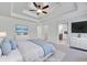 Staged bedroom features tray ceilings, a ceiling fan, a large bed dressed in blues and whites, and dual TV's at 4206 Moccasin Trl, Woodstock, GA 30189