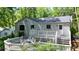 Exterior shot of a home featuring a back deck with outdoor seating and surrounded by mature trees at 7025 Stone Wood Nw Dr, Kennesaw, GA 30152