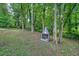 A stone fireplace adds an inviting element to the wooded back yard at 7025 Stone Wood Nw Dr, Kennesaw, GA 30152
