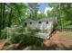 View of home and large wooden deck surrounded by lush greenery at 7025 Stone Wood Nw Dr, Kennesaw, GA 30152