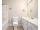 Bright bathroom with a tub/shower, white cabinets, and a large mirror at 7025 Stone Wood Nw Dr, Kennesaw, GA 30152