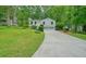 Beautiful home with lush lawn, driveway, two-car garage, and inviting staircase nestled among mature trees at 7025 Stone Wood Nw Dr, Kennesaw, GA 30152