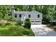 Charming home with manicured lawn, inviting entryway stairs, and two-car garage nestled among mature trees at 7025 Stone Wood Nw Dr, Kennesaw, GA 30152