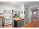 Well-lit kitchen with stainless steel appliances, white cabinets, an island, and hardwood floors at 7025 Stone Wood Nw Dr, Kennesaw, GA 30152