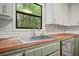Kitchen detail showcases wood counters, tile backsplash, white cabinets, and stainless steel appliances at 7025 Stone Wood Nw Dr, Kennesaw, GA 30152