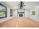 Inviting living room features a stone fireplace, ceiling fan, and large windows, filled with natural light at 7025 Stone Wood Nw Dr, Kennesaw, GA 30152