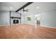 Inviting living room features a stone fireplace, ceiling fan, and hardwood floors, filled with natural light at 7025 Stone Wood Nw Dr, Kennesaw, GA 30152