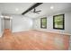 Spacious living room features a stone fireplace, ceiling fan, hardwood floors, and large windows at 7025 Stone Wood Nw Dr, Kennesaw, GA 30152