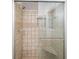 Shower showcasing decorative tile, built-in seat, shower head, and glass sliding door at 7025 Stone Wood Nw Dr, Kennesaw, GA 30152
