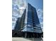 Modern glass high-rise building reflecting the sky with spacious balconies and surrounding trees under scattered clouds at 788 W Marietta Nw St # 512, Atlanta, GA 30318