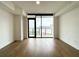 Bright living room featuring hardwood floors, large windows, and a sliding glass door to the balcony at 788 W Marietta Nw St # 512, Atlanta, GA 30318