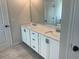 Elegant bathroom with double vanity sinks, white cabinets, and a large mirror at 118 Longhorn Way, Auburn, GA 30011