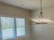 Bright dining room with a modern chandelier and a large window with natural light at 118 Longhorn Way, Auburn, GA 30011