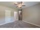 Neutral bedroom featuring plush carpet, a ceiling fan, and hall access at 150 Whitworth Dr, Locust Grove, GA 30248