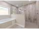 A tiled main bathroom features a large glass shower enclosure, a separate tub, and a window at 150 Whitworth Dr, Locust Grove, GA 30248