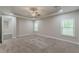 A carpeted main bedroom suite features a tray ceiling, recessed lights, and two bright windows at 150 Whitworth Dr, Locust Grove, GA 30248