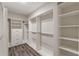 A spacious walk-in closet features custom shelving and storage with wood-look floors at 150 Whitworth Dr, Locust Grove, GA 30248