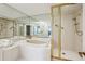 Bright bathroom featuring an enclosed shower, soaking tub, and gold fixtures at 2660 Peachtree Nw Rd # 23A, Atlanta, GA 30305