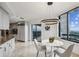 Bright eat in kitchen with city views from the adjacent windows; modern lighting fixtures and countertops at 2660 Peachtree Nw Rd # 23A, Atlanta, GA 30305