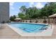 Large community pool surrounded by lounge chairs and lush greenery at 2660 Peachtree Nw Rd # 23A, Atlanta, GA 30305