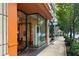 Bright storefront with large windows showcasing art inside Buckhead Art & Company along a tree-lined sidewalk at 2660 Peachtree Nw Rd # 23A, Atlanta, GA 30305