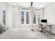 Bright bedroom with neutral carpet and white walls features a workstation and three large windows at 1244 Chelsea Nw Cir, Atlanta, GA 30318