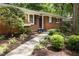 Charming brick home with dark shutters and a manicured lawn, enhanced by landscape lighting at 1597 Fama Ne Dr, Atlanta, GA 30329