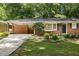 Charming brick home featuring a covered carport, complemented by a beautifully landscaped front yard at 1597 Fama Ne Dr, Atlanta, GA 30329