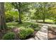 Beautifully landscaped front yard with mature trees, shrubs, and a long driveway leading to a charming home at 1597 Fama Ne Dr, Atlanta, GA 30329