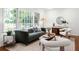 Well-lit living room with modern furniture, neutral rug, and views of the lush backyard at 1597 Fama Ne Dr, Atlanta, GA 30329