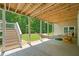 Covered back patio with a hammock, chairs, and staircase leading to the landscaped backyard at 208 Wilshire Ter, White, GA 30184
