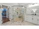 Modern bathroom showcasing a glass shower with bench, double vanity, and neutral tile flooring at 208 Wilshire Ter, White, GA 30184