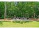 Outdoor firepit area surrounded by mature trees, perfect for entertaining at 208 Wilshire Ter, White, GA 30184