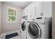 Bright laundry room equipped with modern appliances, upper cabinets, and ample space for organization at 208 Wilshire Ter, White, GA 30184