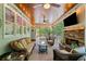 Charming screened-in porch with a cozy fireplace, ceiling fans, and ample seating for relaxing outdoors at 208 Wilshire Ter, White, GA 30184