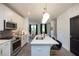 Stylish kitchen with white cabinetry, an island with seating, and stainless steel appliances at 392 Pratt Dr # 2014, Atlanta, GA 30315
