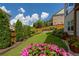 Landscaped backyard featuring a manicured lawn, beautiful flowers, and a wooden fence for added privacy at 4503 Atley Woods Se Dr, Atlanta, GA 30339