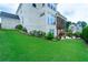 Landscaped backyard featuring lush green lawn, patio area with fire pit, and manicured garden beds at 4503 Atley Woods Se Dr, Atlanta, GA 30339